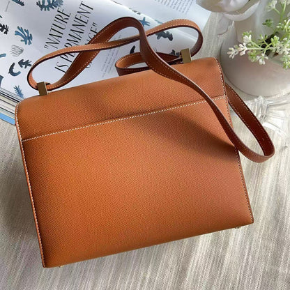 Brown leather handbag on a light wooden surface