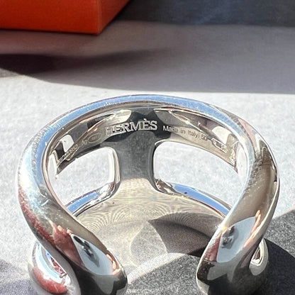 Silver Hermès bracelet on a textured surface