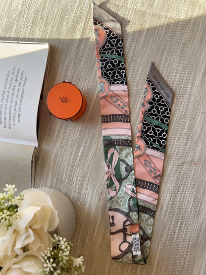 Patterned tie on a wooden surface with an open book and small round object nearby.