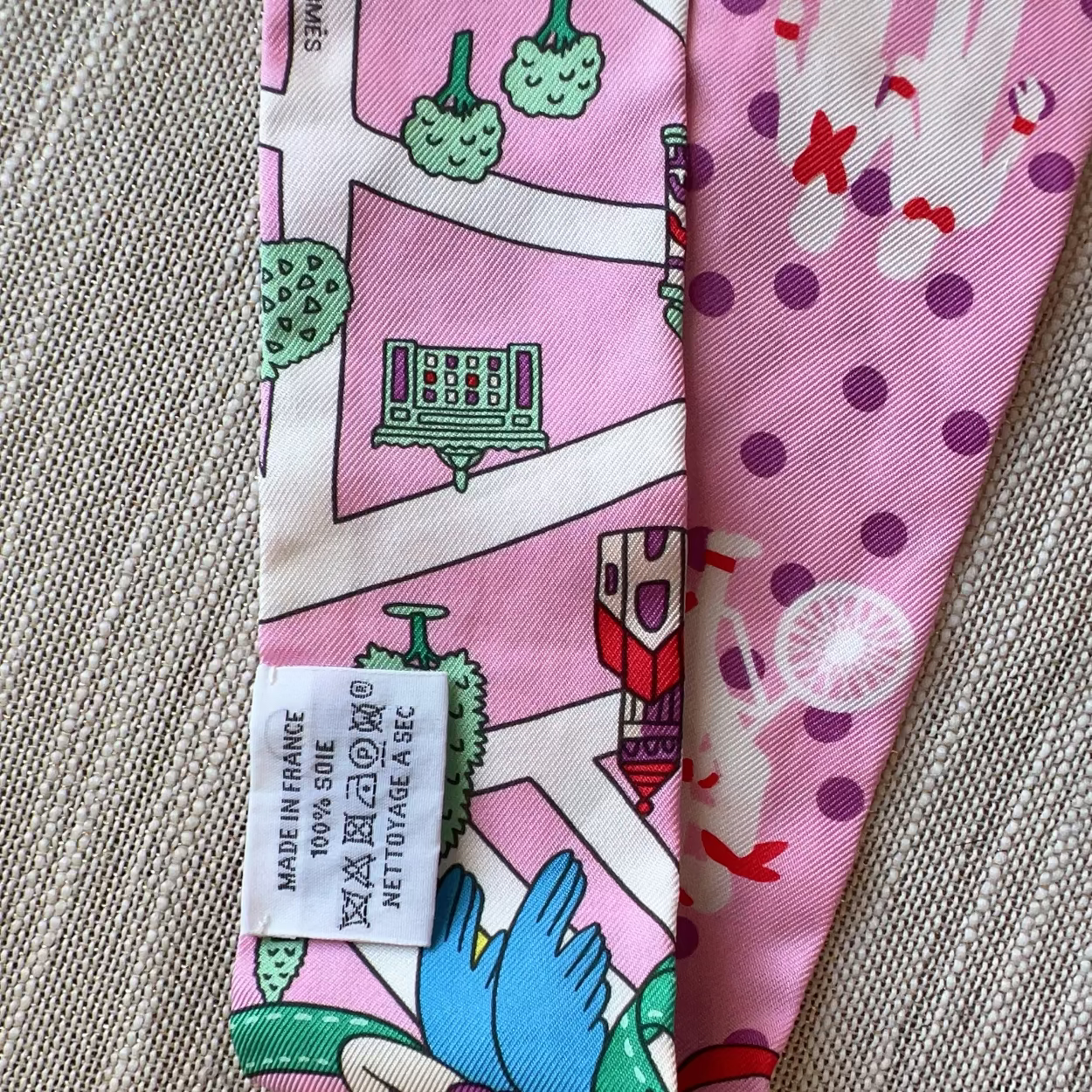 Two pink fabric swatches with cartoon designs on a textured surface