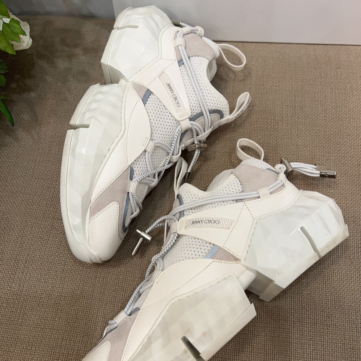 Pair of white and gray sneakers on a textured surface