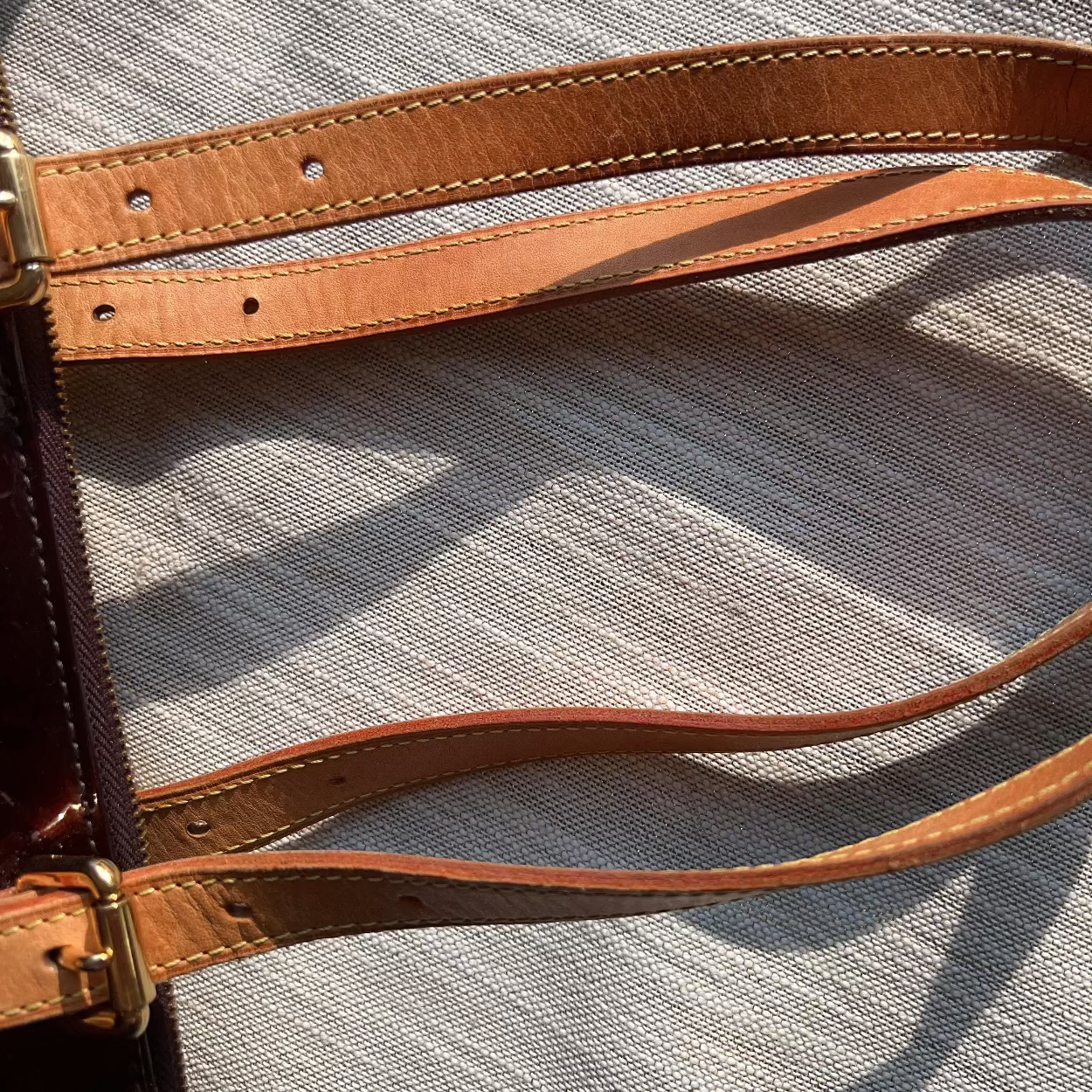 Close-up of a brown leather strap on a textured surface