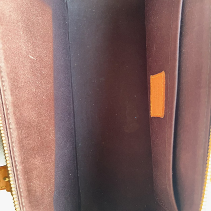 Close-up of a brown leather bag with a gold zipper.