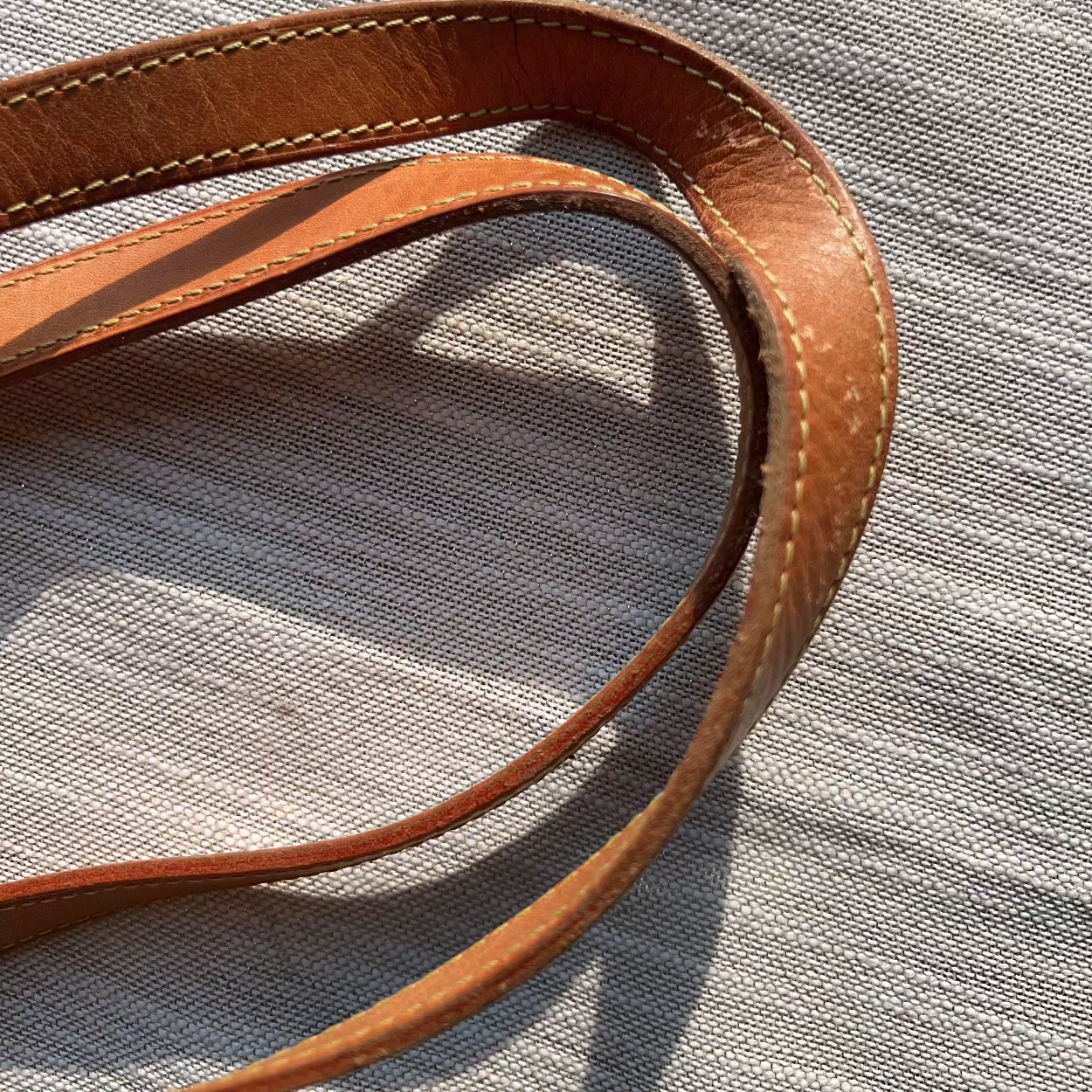 Brown leather strap on a textured gray surface