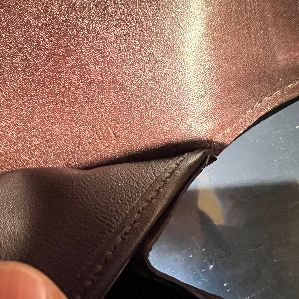 Close-up of brown leather surface with visible stitching