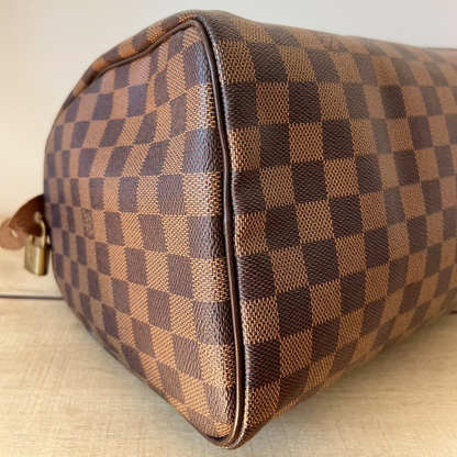 Brown checkered handbag on a beige surface