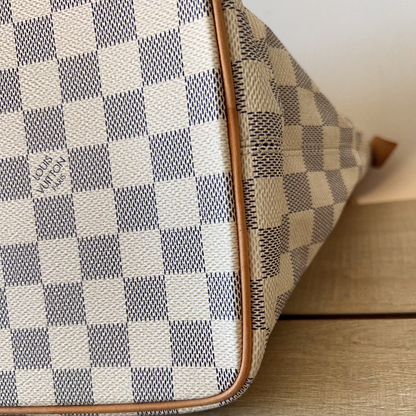 Checkered handbag with visible brand logo on a wooden surface