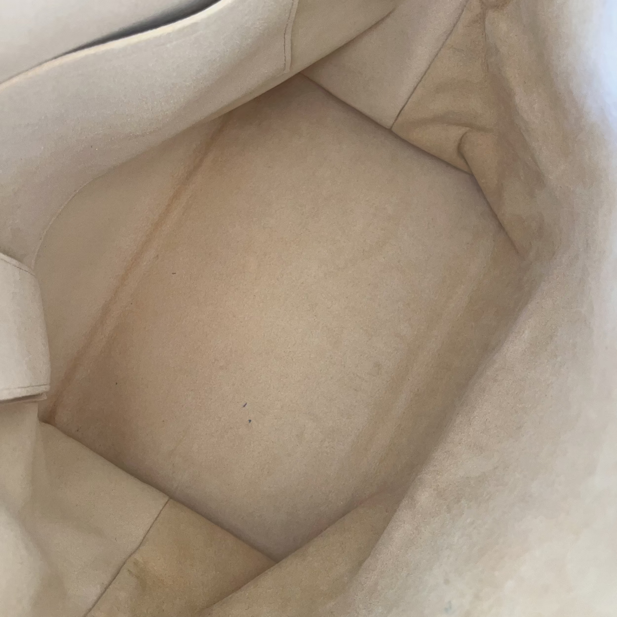 Close-up of beige leather car interior with visible wear and tear.