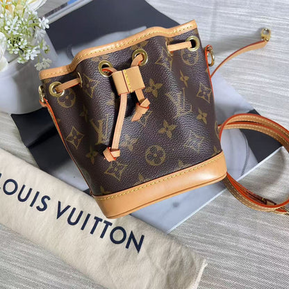 Louis Vuitton monogram handbag with tan leather accents on a textured surface.
