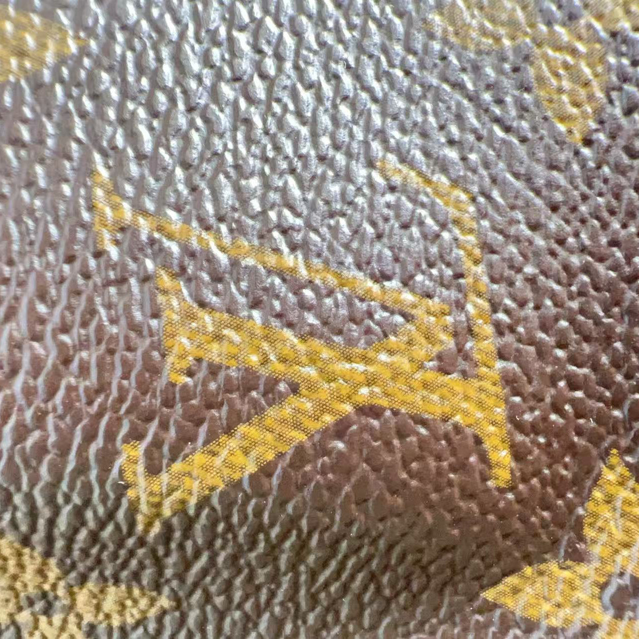 Close-up of a textured surface with a yellow logo on a brown background