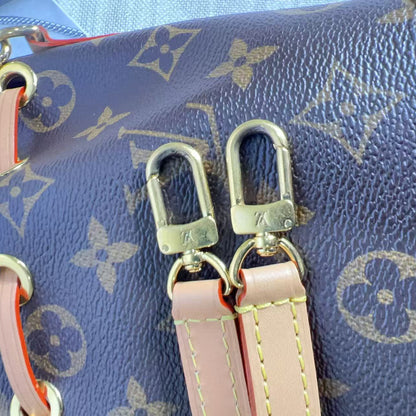Close-up of a blue handbag with gold hardware and pink straps.
