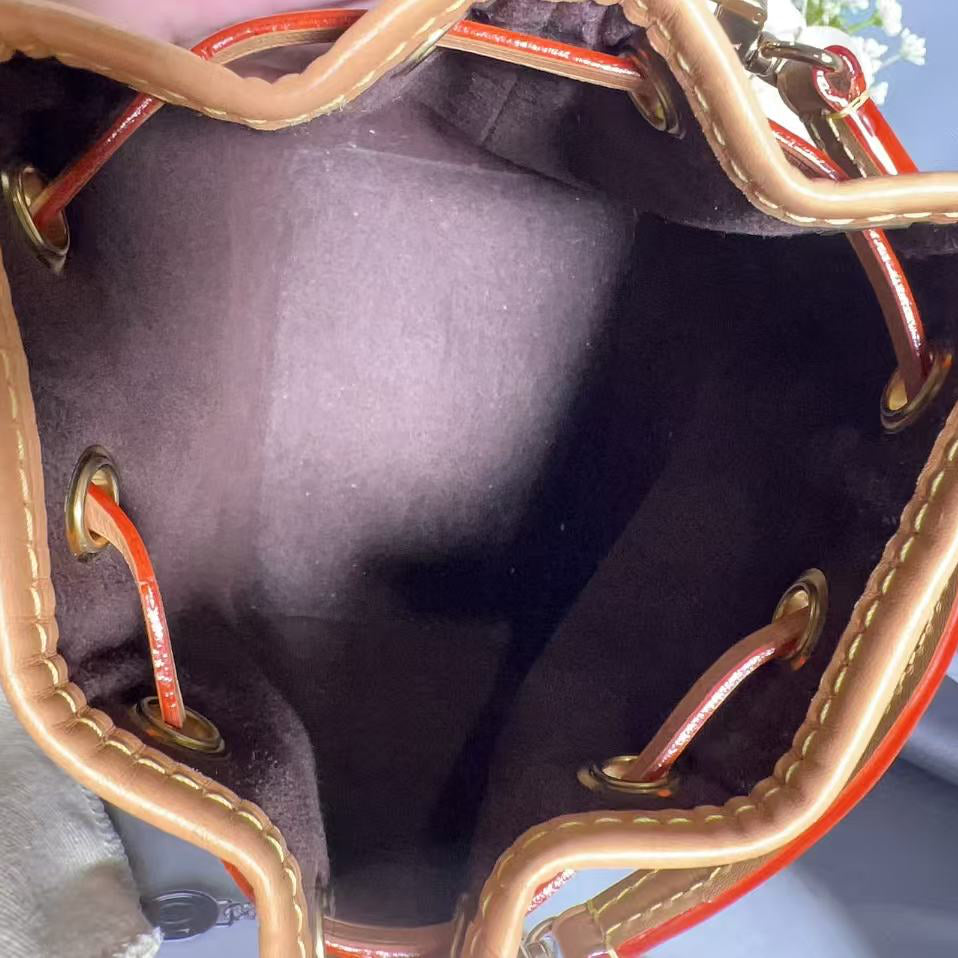 Close-up of a brown leather handbag with gold stitching