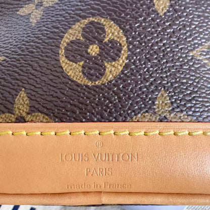 Louis Vuitton wallet with monogram pattern and tan leather trim.