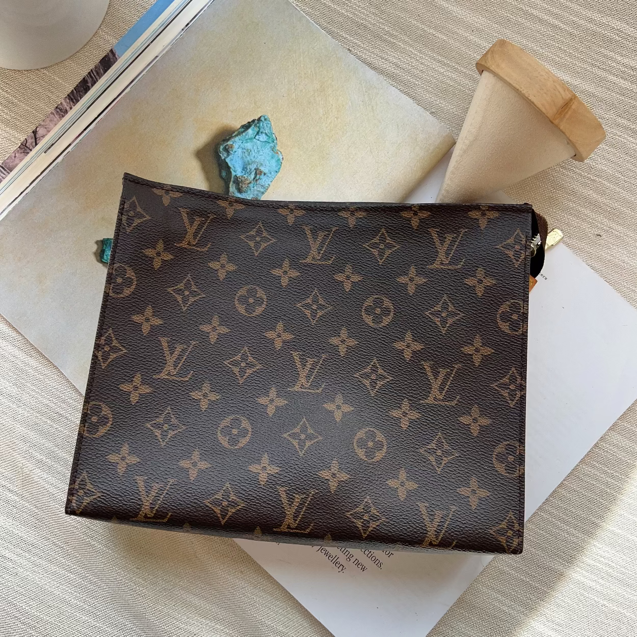 Designer handbag with monogram pattern on a wooden surface