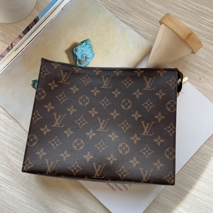 Designer handbag with monogram pattern on a wooden surface