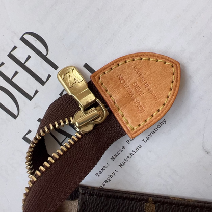 Close-up of a brown leather zipper pull on a book with visible branding.