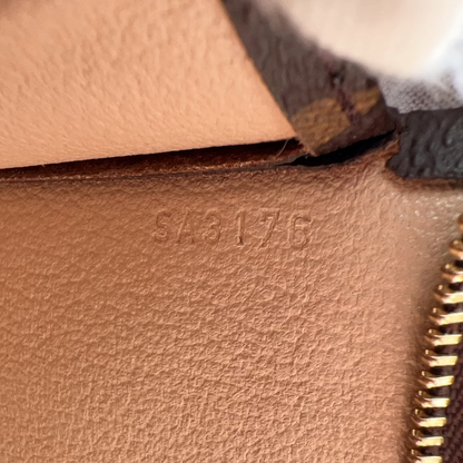 Close-up of a brown leather bag with gold zipper and visible brand stamp.