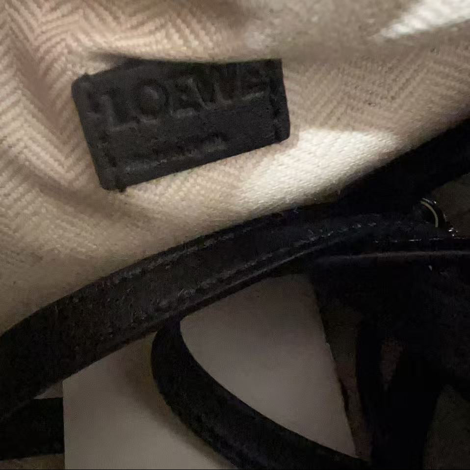 Close-up of a black logo on a textured beige surface