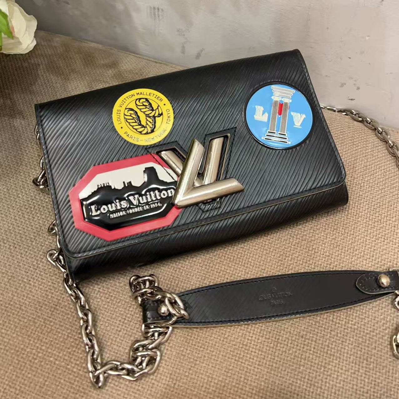 Black handbag with colorful patches on a textured surface