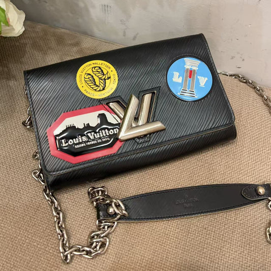 Black handbag with colorful patches on a textured surface