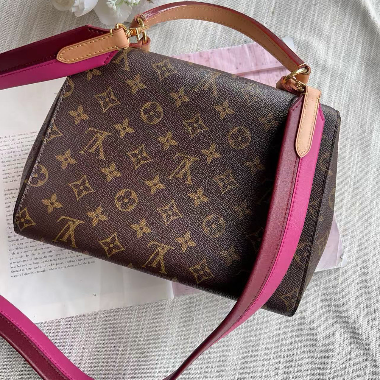 Designer handbag with monogram pattern on a light background