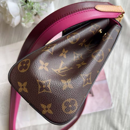 Brown leather handbag with gold monogram pattern on a pink strap.