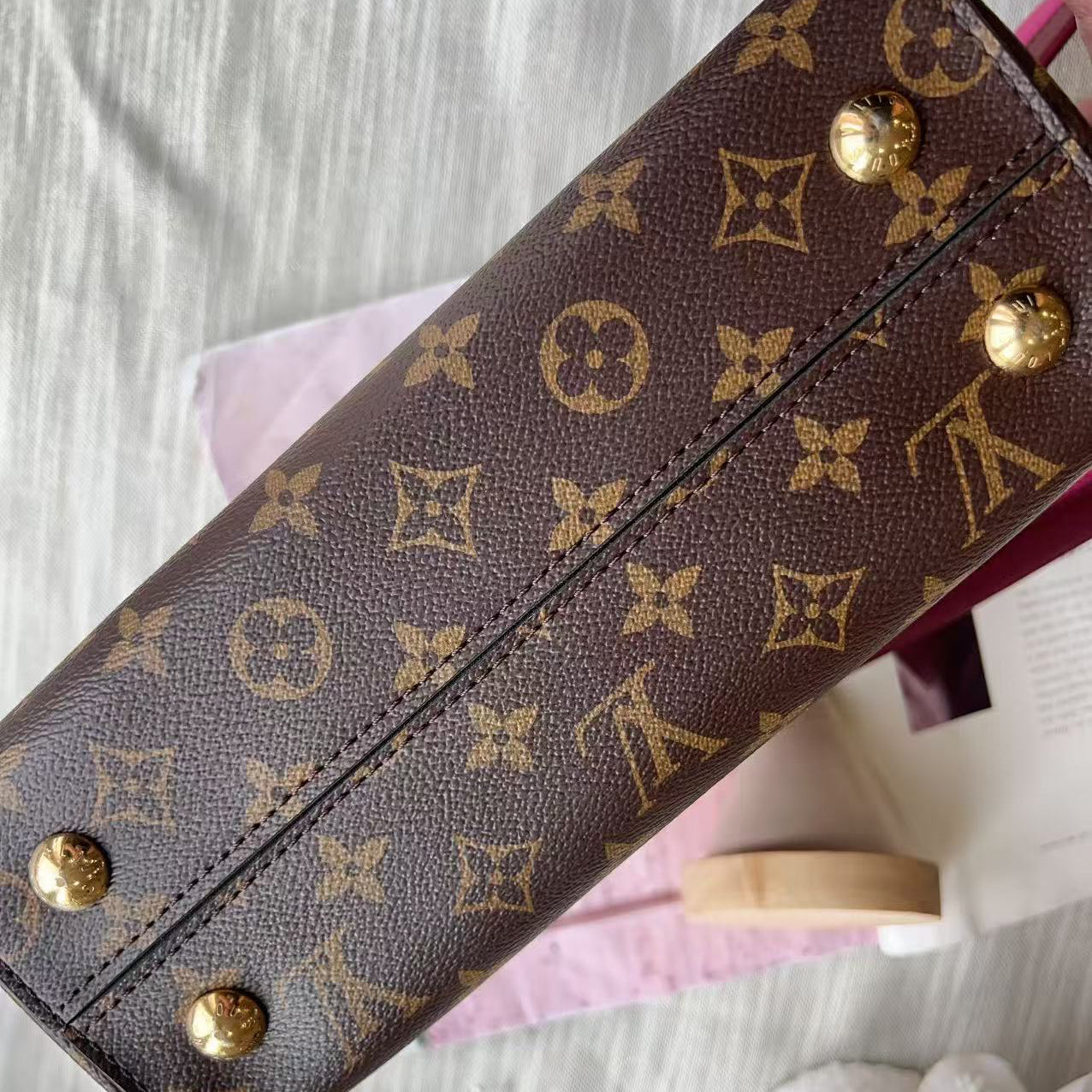 Louis Vuitton wallet with monogram pattern on a light background