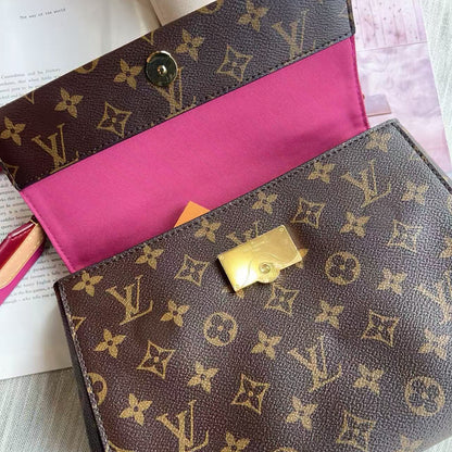Louis Vuitton monogram handbag with pink interior on a light gray surface