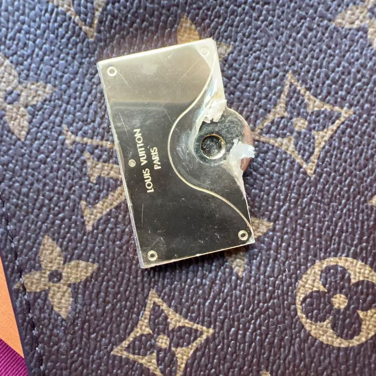 Small metal object on a Louis Vuitton patterned surface