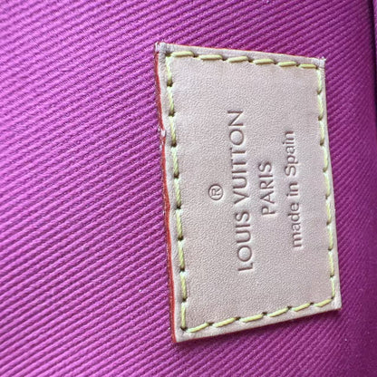 Louis Vuitton label on a purple textured surface