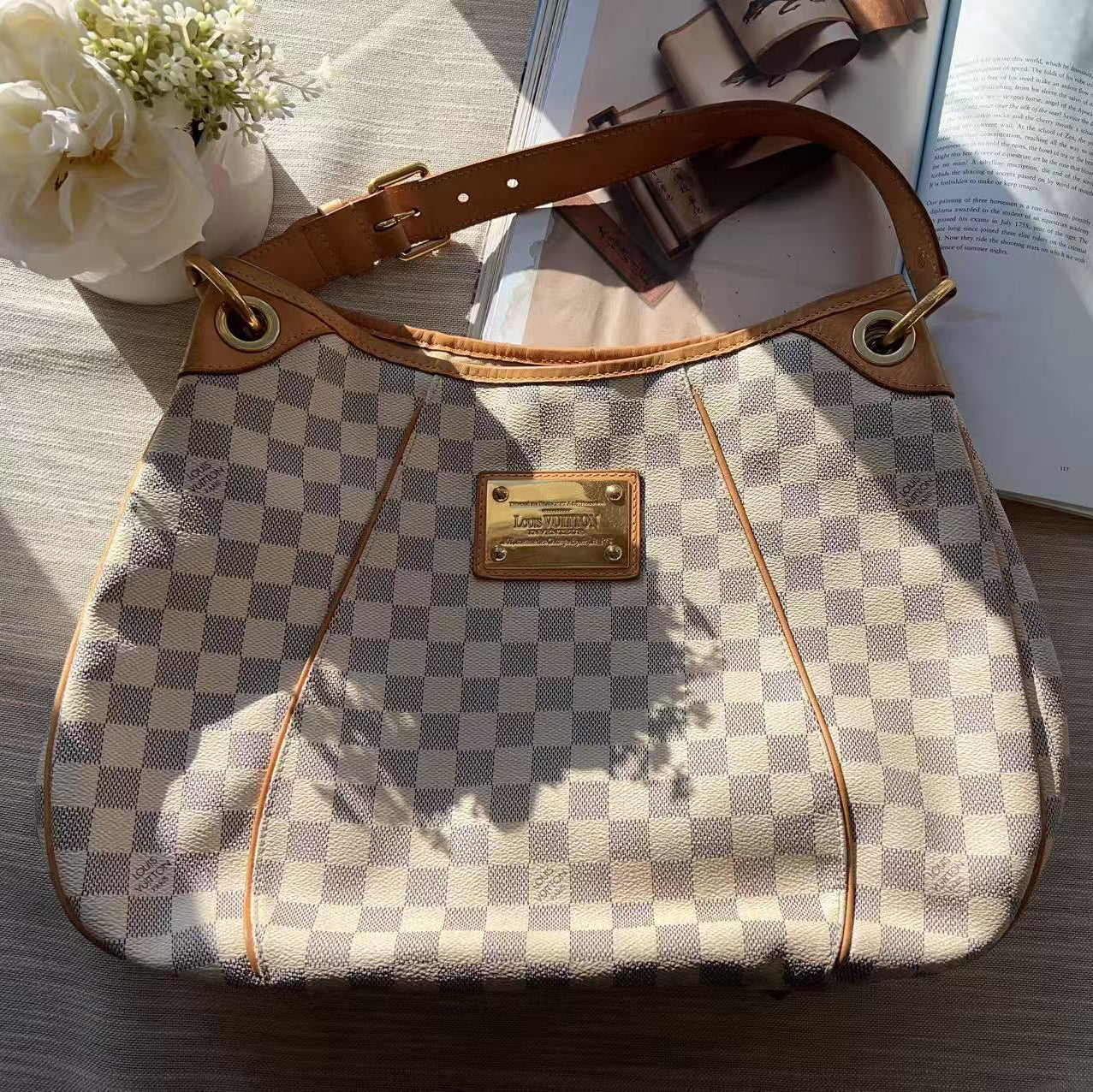 Checkered handbag with gold accents on a wooden surface