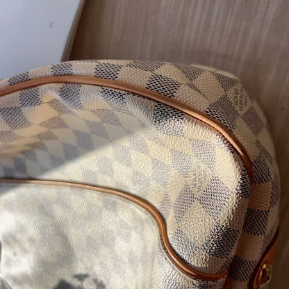 Designer handbag with checkered pattern on a wooden surface