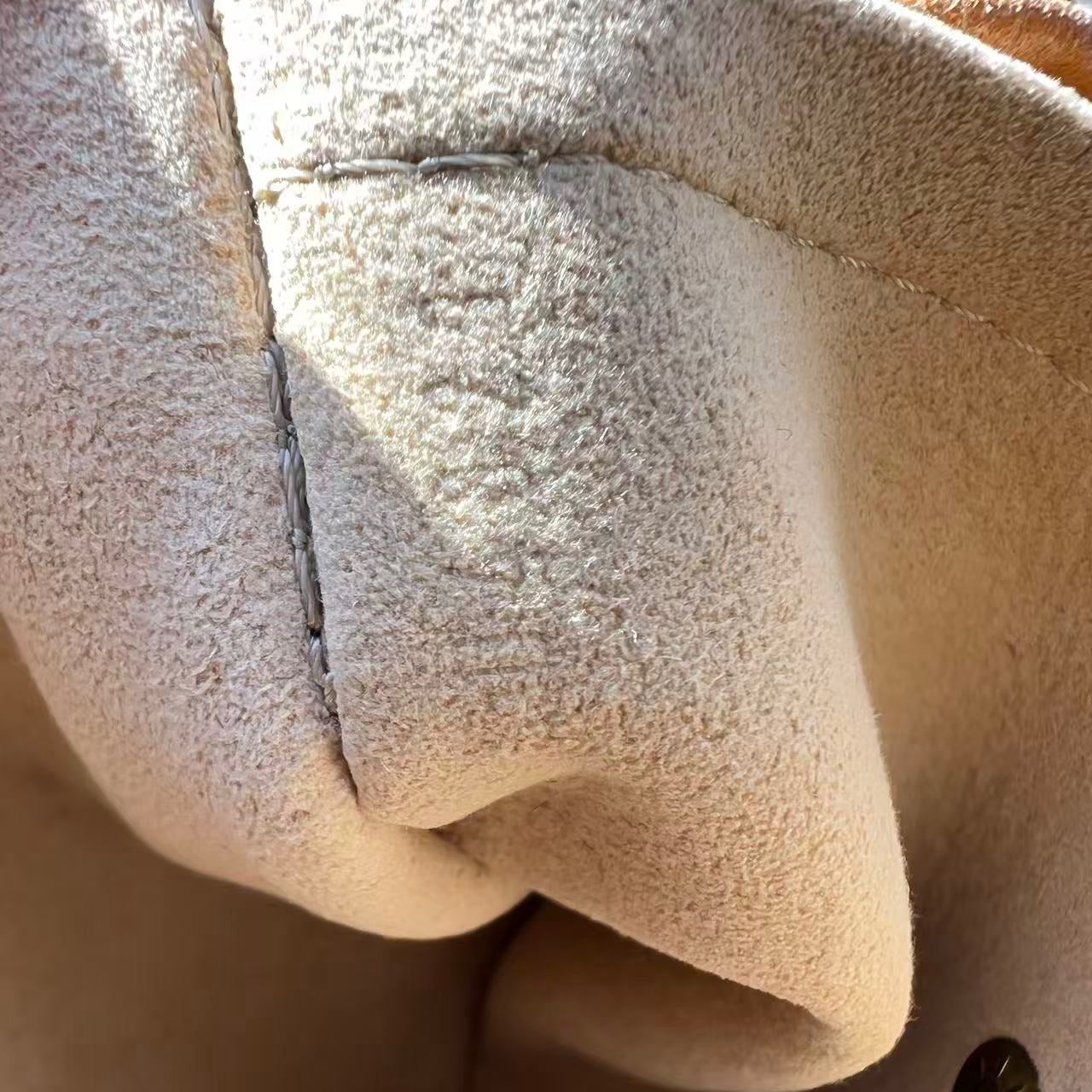 Close-up of a textured beige fabric surface with a button.