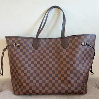 Designer handbag with checkered pattern on a beige couch