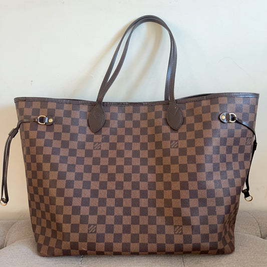 Designer handbag with checkered pattern on a beige couch