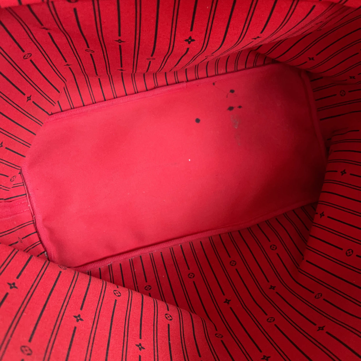 Red fabric with black patterns and a visible zipper