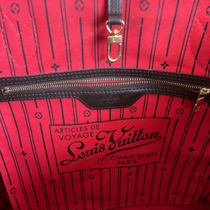 Red Louis Vuitton bag with black pattern and gold zipper.