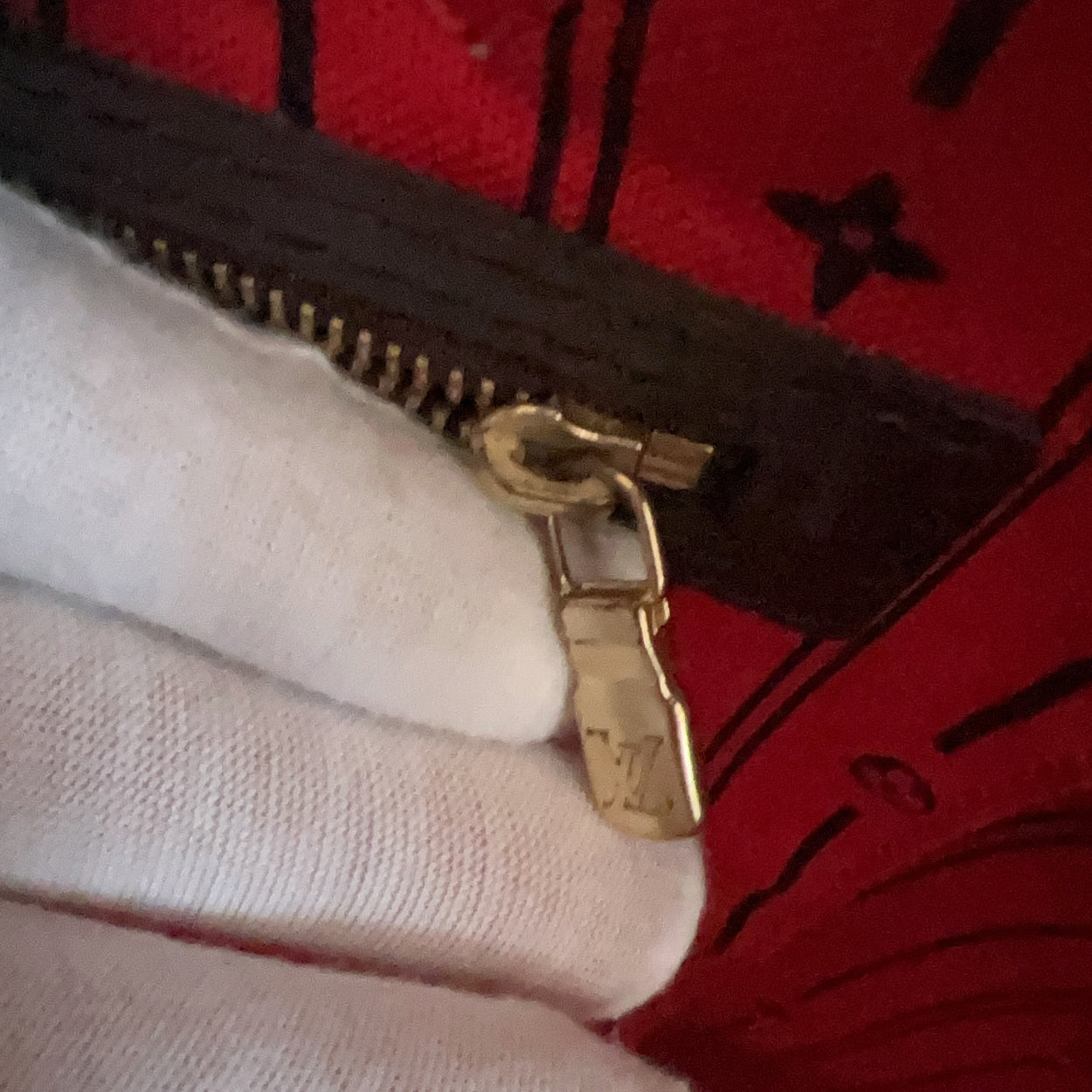 Close-up of a gold zipper on a red fabric background