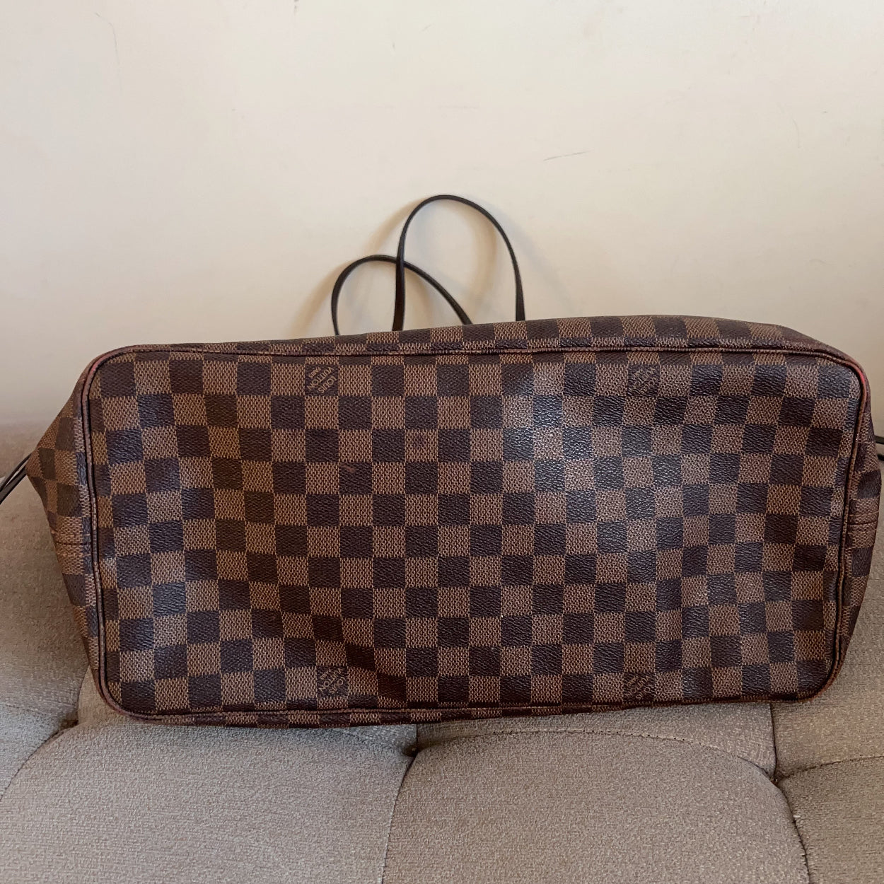 Checkered brown and blue bag on a beige couch