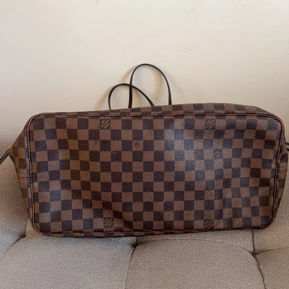 Checkered brown and blue bag on a beige couch