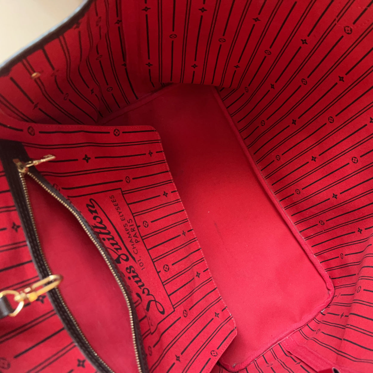 Close-up of a red Louis Vuitton bag interior with visible branding.