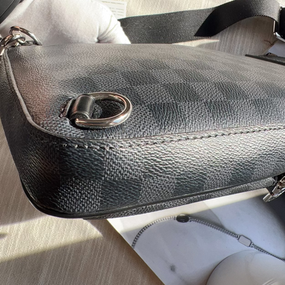 Black textured handbag with a silver clasp on a light surface