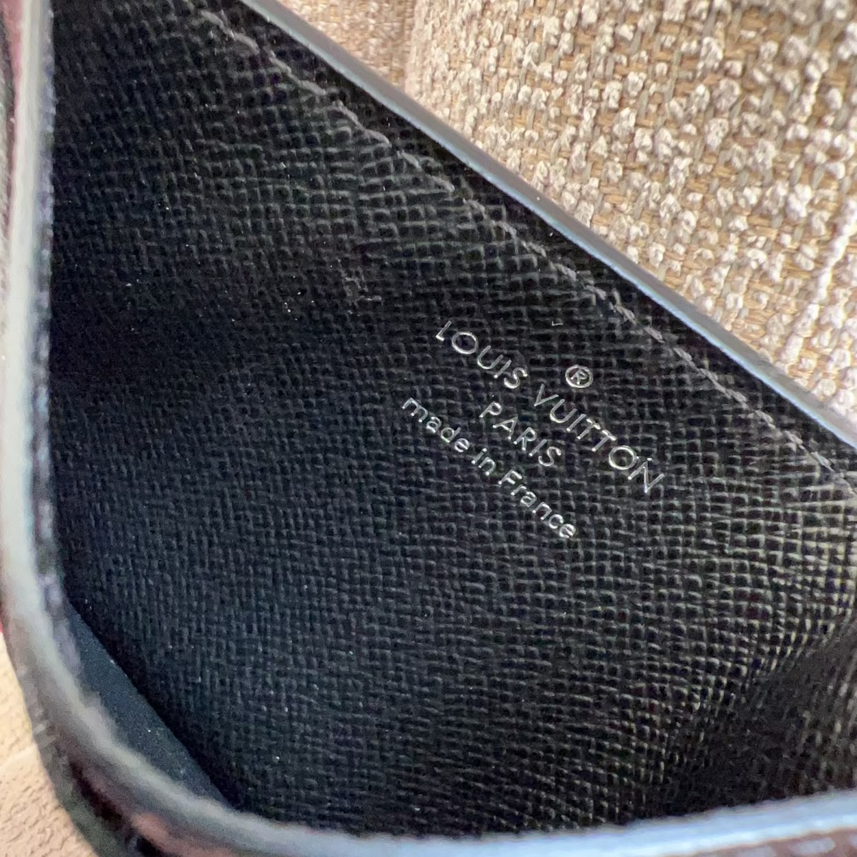 Close-up of a Louis Vuitton wallet with visible branding.