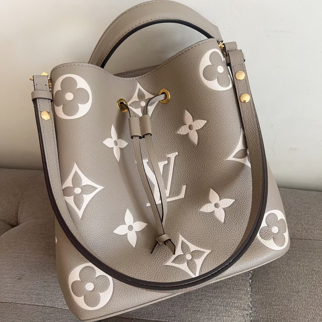 Designer handbag with brand logo on a neutral background