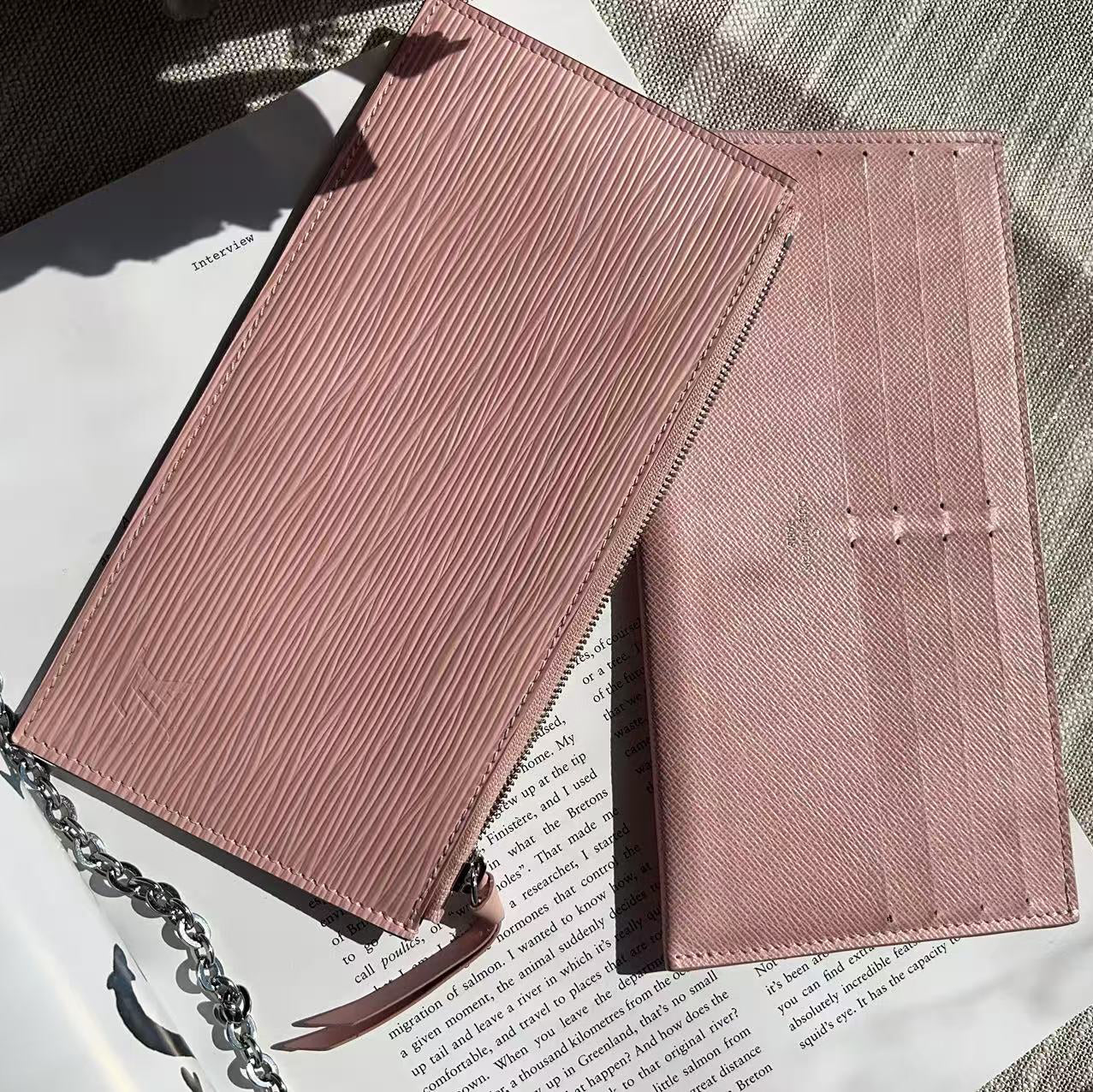 Pink textured wallet on a newspaper with a chain detail