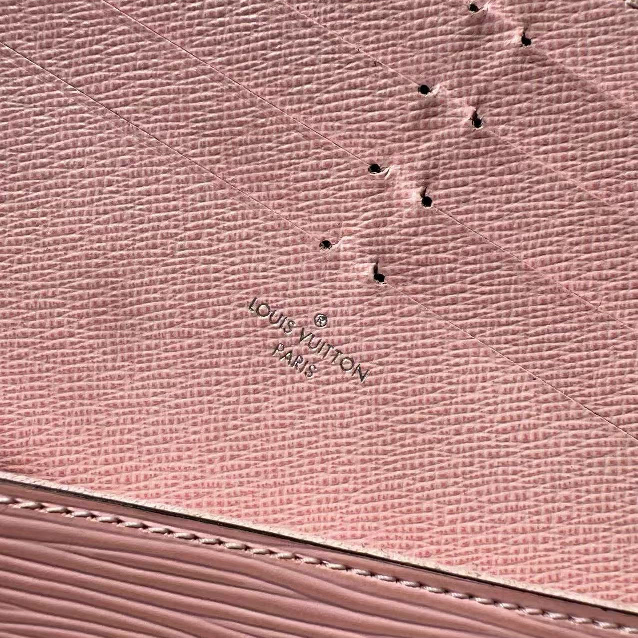 Close-up of a pink textured surface with a brand logo.