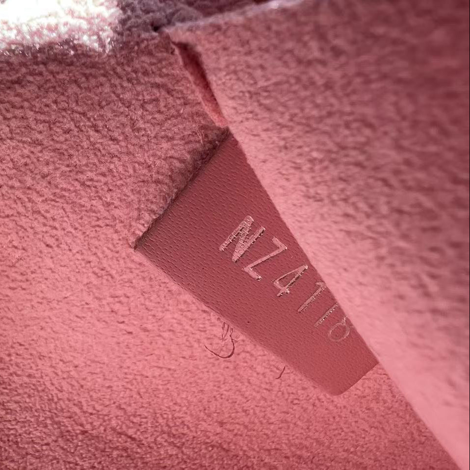 Close-up of a pink textured fabric with a visible brand label.