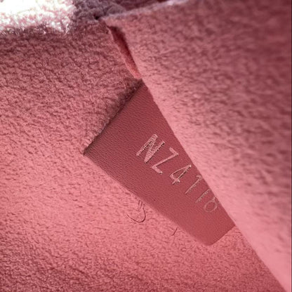 Close-up of a pink textured fabric with a visible brand label.