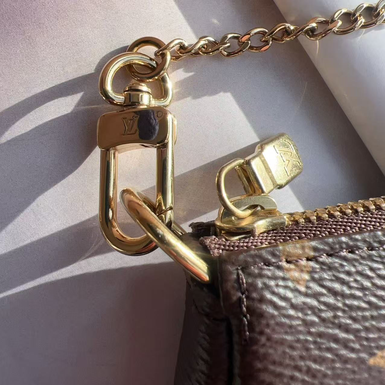 Close-up of a gold chain and clasp on a textured surface