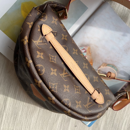 A Louis Vuitton monogrammed half-moon shoulder bag in brown coated canvas with tan leather trim, shown resting on a light-colored textured surface with printed papers underneath.